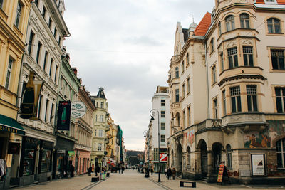 Street amidst buildings in town against sky