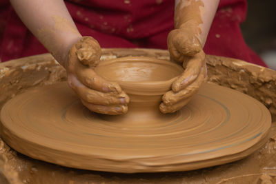 Midsection of man making pot