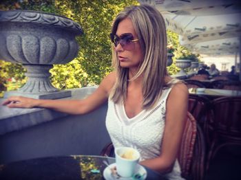 Young woman sitting by coffee on chair