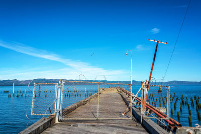 Pier over sea against blue sky
