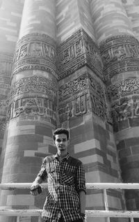 Low angle portrait of young man against historic building