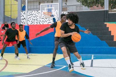 Men playing basket ball on court