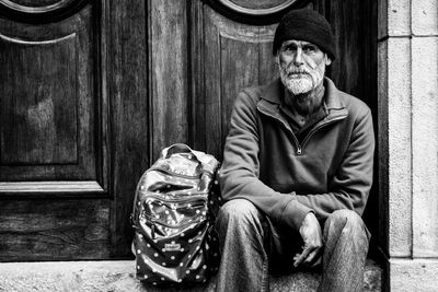 Portrait of man wearing hat sitting outdoors