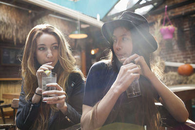 Happy young friends enjoying drinks at a bar