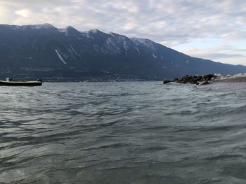 Scenic view of sea and mountains against sky