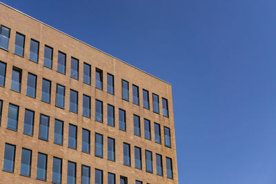 Low angle view of building against clear blue sky