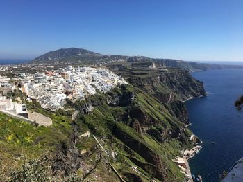 High angle view of townscape by sea against clear sky