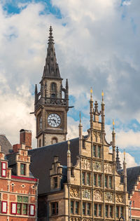 Low angle view of buildings against cloudy sky