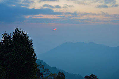 Scenic view of silhouette mountains against sky at sunrise or sunset.