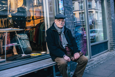 Full length of man sitting by window