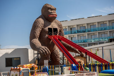 Low angle view of statue against buildings in city