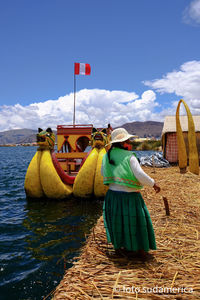 Rear view of people on boat against sky