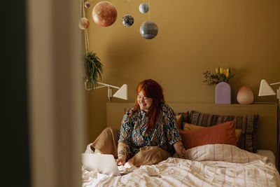 Woman on bed using laptop