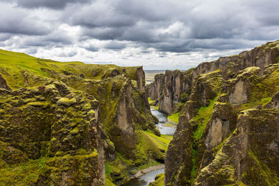 Scenic view of rock formations against cloudy sky