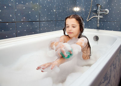 Young woman in bathtub at home
