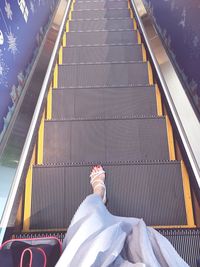 Low section of woman on escalator