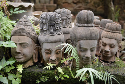 Close-up of statues on moss covered wall