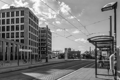 Railroad tracks by buildings in city against sky