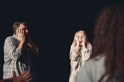 Male and female stage performers practicing emotions together in class