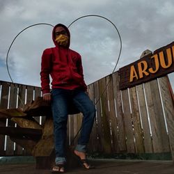 Full length portrait of young man standing against sky