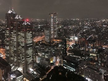Aerial view of illuminated buildings in city at night