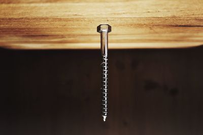 Upside down image of nail on wooden table