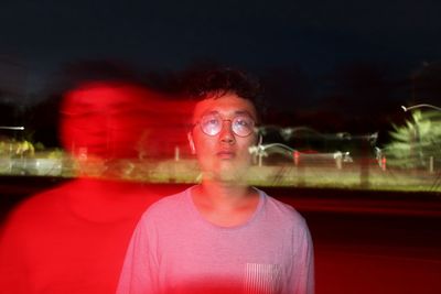 Portrait of man against illuminated red light at night