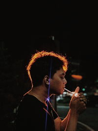 Young man looking at camera at night