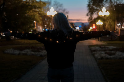 Rear view of woman standing on footpath