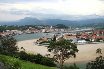 High angle view of town by sea against sky