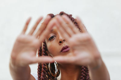 Portrait of woman gesturing against wall