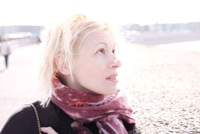 Close-up of woman at beach against sky during winter