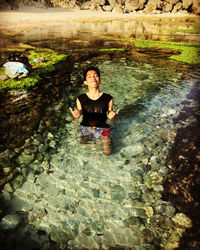 Portrait of young woman in water