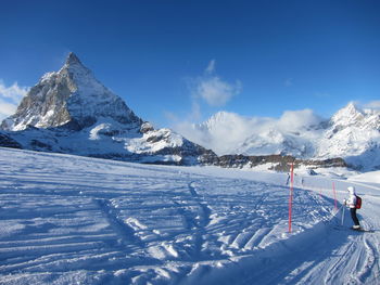 Side view of person skiing on snowfield against sky