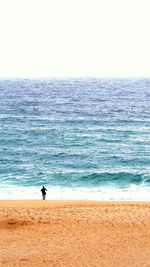 Man standing on beach against clear sky