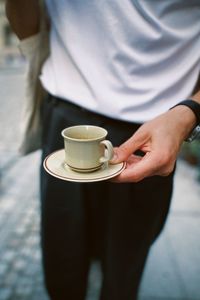 Midsection of woman holding coffee cup