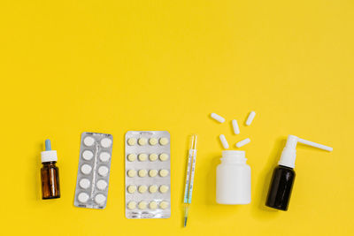 Medicines from home medical kit.  healthcare concept. yellow background, flat lay, close up.