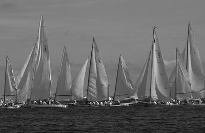 Sailboats sailing in sea against sky