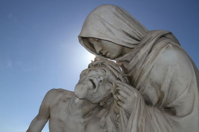 Close-up of pieta statue against clear blue sky