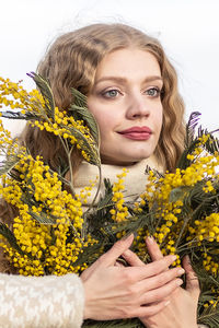 A woman  with a bouquet of yellow acacia flowers.the concept of the- march 8, easter, women's day.