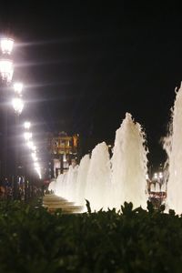 Illuminated buildings against sky at night