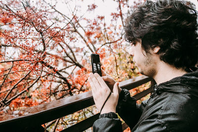 Close-up of young man photographing with mobile phone