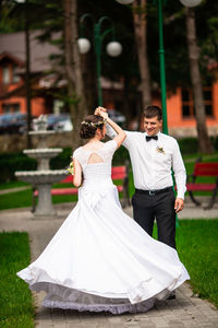 Low section of bride standing in park