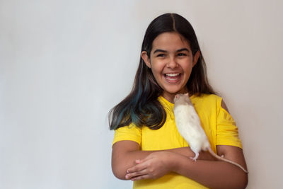 Smiling teenage girl with rat against white background