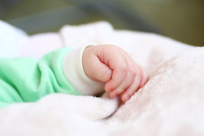 Cropped hand of child on blanket