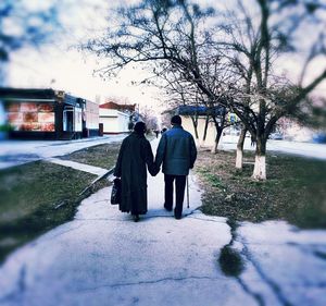 Rear view of couple walking in winter