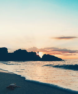 Scenic view of beach against sky during sunset