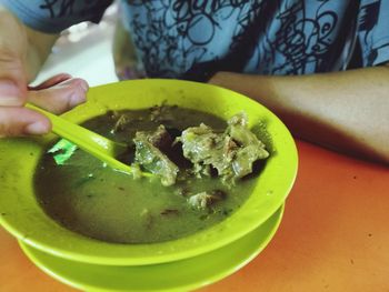 Close-up of hand holding soup in bowl