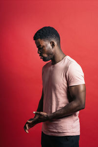 Man looking away against red background