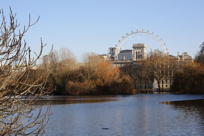 Scenic view of lake by buildings against clear sky